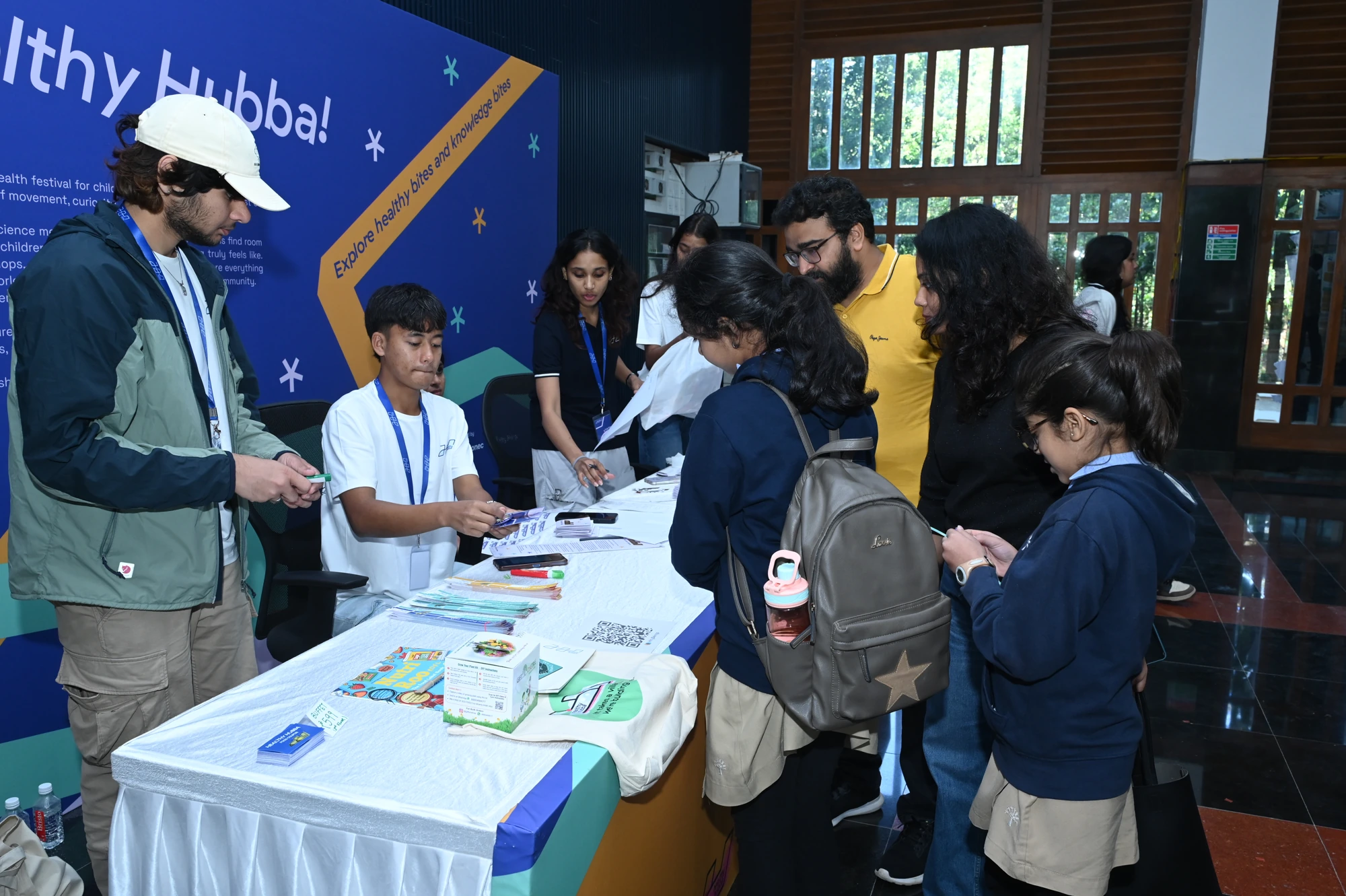 Attendees at the welcome table with the Healthy Hubba welcome graphic installed behind them